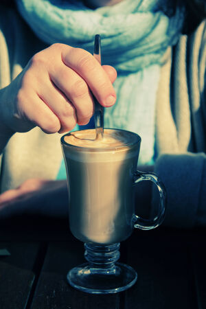 woman is holding cup of coffee cappuccinoの写真素材