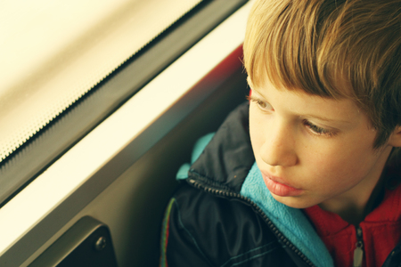 Cute Boy looking through the windowの写真素材