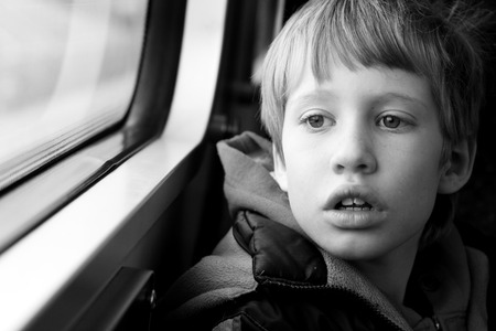 Cute Boy looking through the windowの写真素材