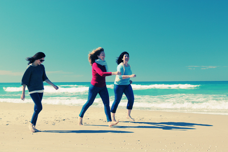 Three best friends walking at seasideの写真素材
