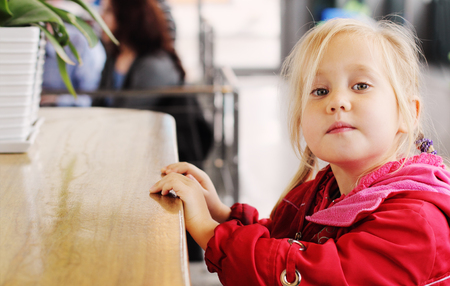 Adorable 4 years old girl sitting in cafeの写真素材