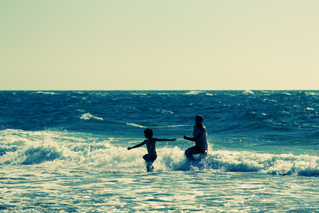 father and son walking on the beachの写真素材