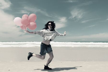 beautiful woman holding red balloonsの写真素材