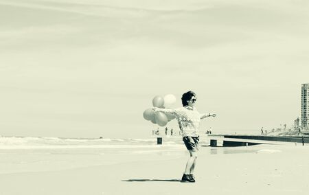 beautiful woman holding red balloonsの写真素材
