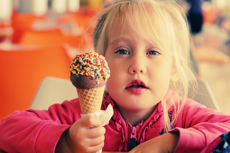 portrait of beautiful happy girl eating ice creamの写真素材