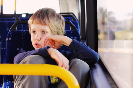 Cute autistic boy sitting in empty busの写真素材