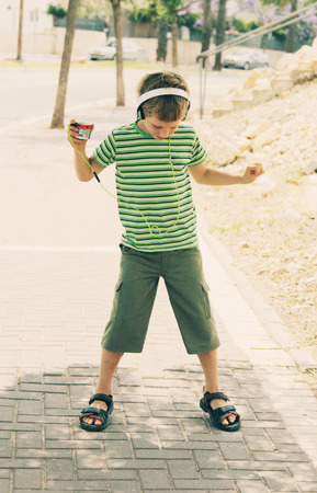 Cute autistic boy with headphones dancing in the streetの写真素材