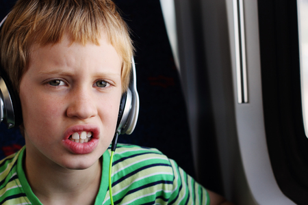 Portrait of cute boy with headphones traveling in the trainの写真素材