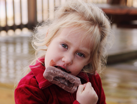 cute 4 years old girl eating ice creamの写真素材