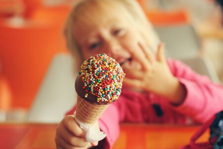 portrait of beautiful happy girl eating ice creamの写真素材