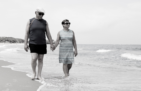 senior couple walking on the beachの写真素材