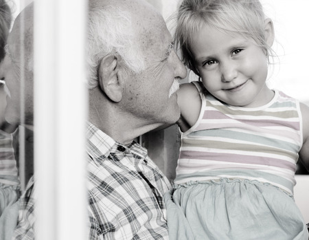 grandfather holding his 4 years old granddaughter