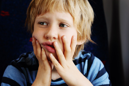 Cute 7 years old boy traveling in the trainの写真素材
