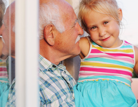 grandfather holding his 4 years old granddaughterの写真素材