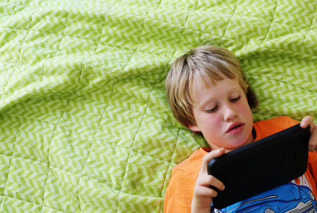 Cute 7 years old boy using laptopの写真素材