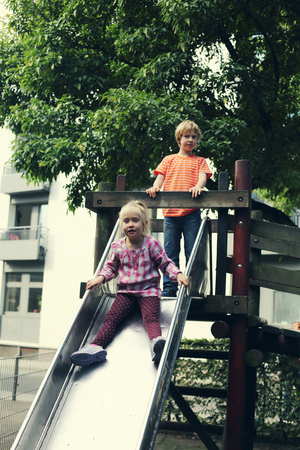 brother and sister playing on the playgroundの写真素材