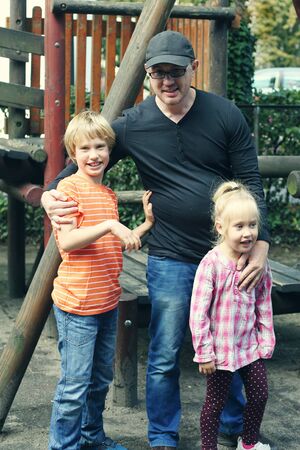 Father and kids playing on the playgroundの写真素材