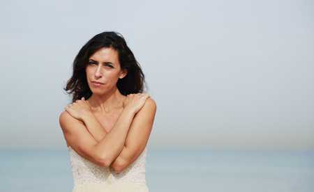 beautiful 35 years old woman standing on the shore of the beachの写真素材