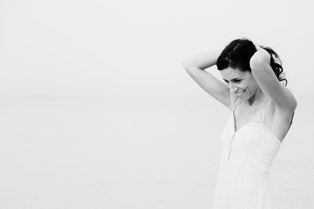 beautiful 35 years old woman standing on the shore of the beachの写真素材