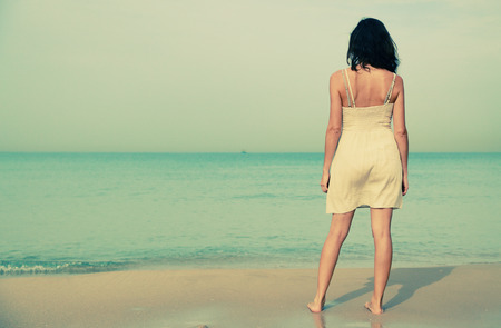 beautiful woman standing on the shore of the beachの写真素材