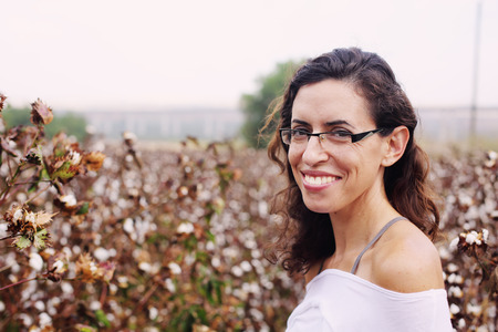 beautiful woman standing in cotton fieldの写真素材