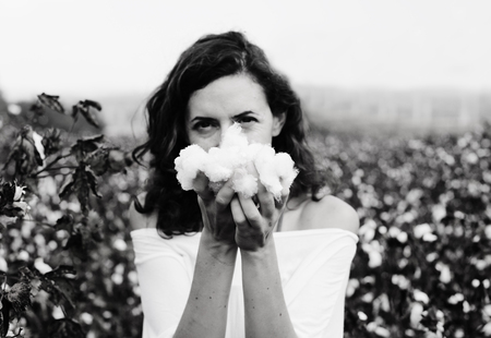 beautiful woman holding natural cotton. Focus on the armsの写真素材