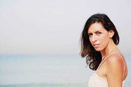 beautiful 35 years old woman standing on the shore of the beach