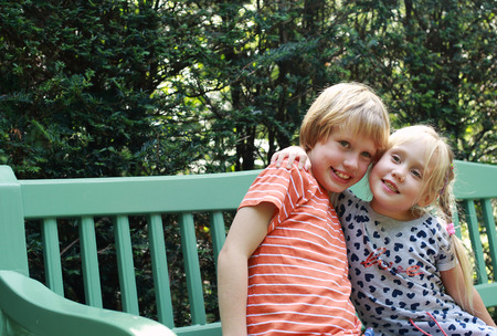 Portrait of happy girl with her autistic brother outdoorsの写真素材