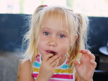 Portrait of 5 years old girl eating choÑolateの写真素材