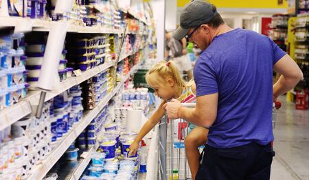 Dad and daughter buying food in the supermarketの写真素材