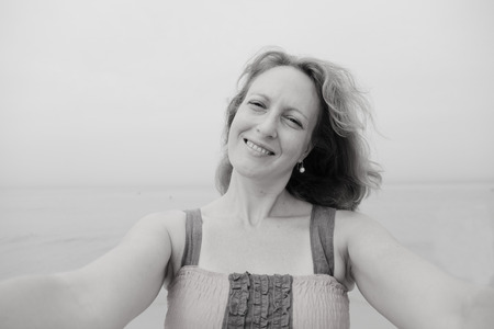 Beautiful woman smiling on the beach. Selfie.の写真素材