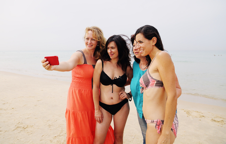 four best girlfriends making selfie-photo at seasideの写真素材