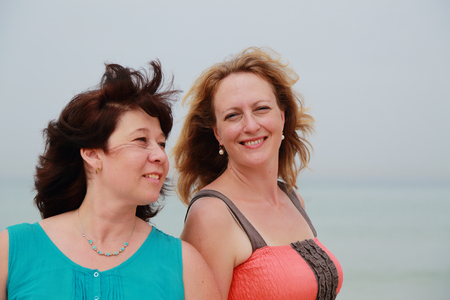 best friends walking at seasideの写真素材