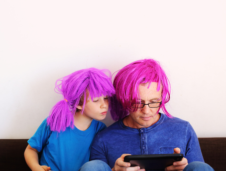 father and son playing games on tabletsの写真素材