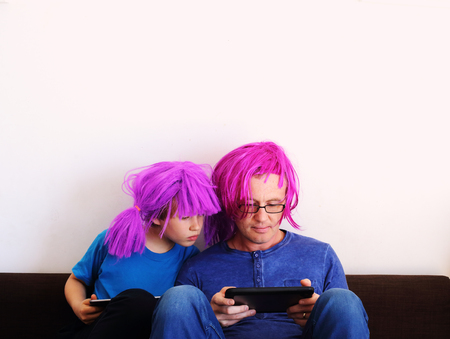 father and son playing games on tabletsの写真素材