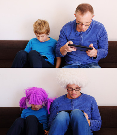 father and son playing games on tabletsの写真素材