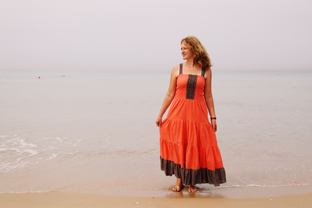 Beautiful woman standing on the beachの写真素材