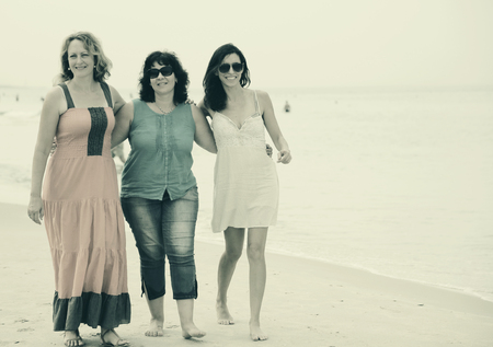 Three best friends walking at seasideの写真素材