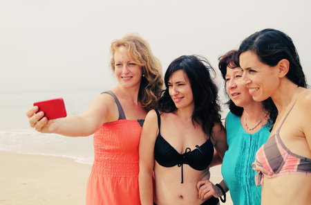 four best girlfriends making selfie-photo at seasideの写真素材