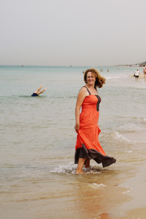 Beautiful woman walking on the beachの写真素材