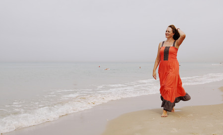 Beautiful woman walking on the beachの写真素材