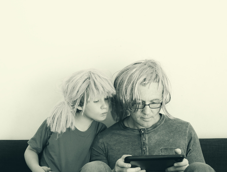 father and son playing games on tabletsの写真素材