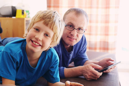 father and son playing games on tabletsの写真素材