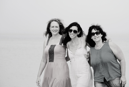 Three best friends walking at seasideの写真素材
