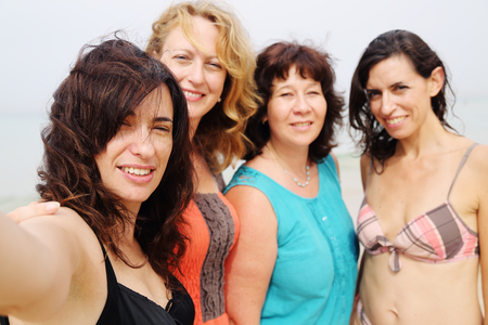 four best girlfriends making selfie-photo at seasideの写真素材