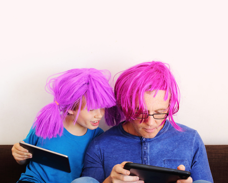 father and son playing games on tabletsの写真素材