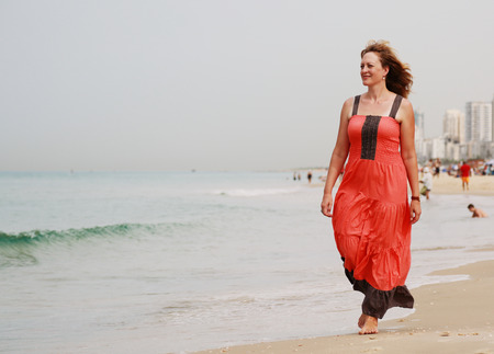 Beautiful woman walking on the beachの写真素材