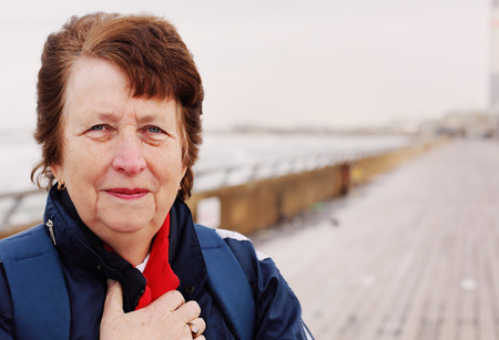 Senior woman standing on the winter beachの写真素材