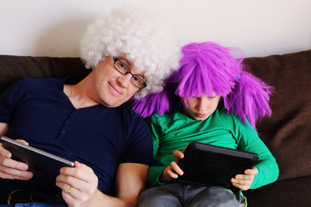 father and son playing games on tabletsの写真素材