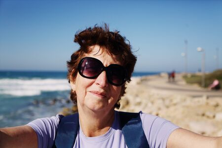 Portrait of happy senior woman travelingの写真素材